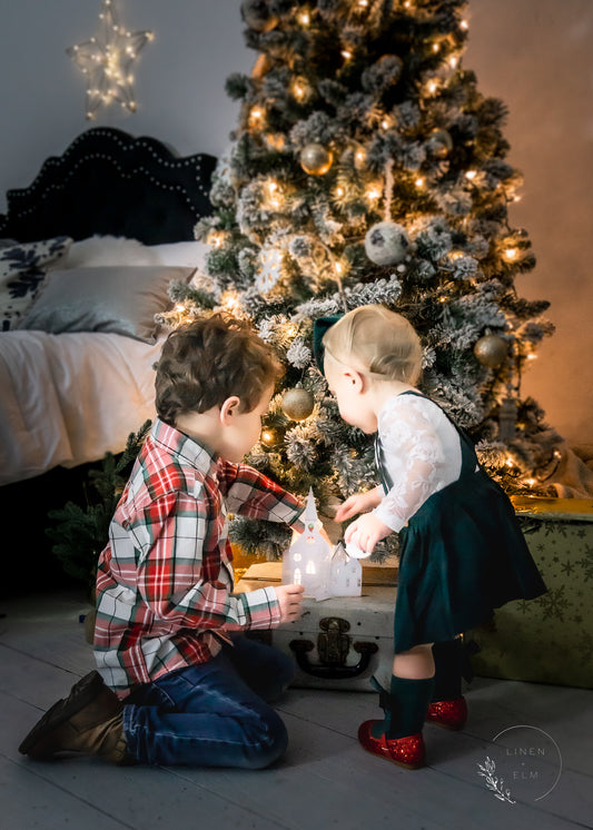 Mini session with children near lit tree in darker room